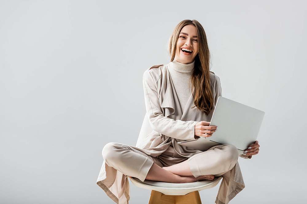 Symbolbild Businessplanung: 10 Fragen für das viertel Quartal. Frau sitzt mit Laptop auf einem Hocker.