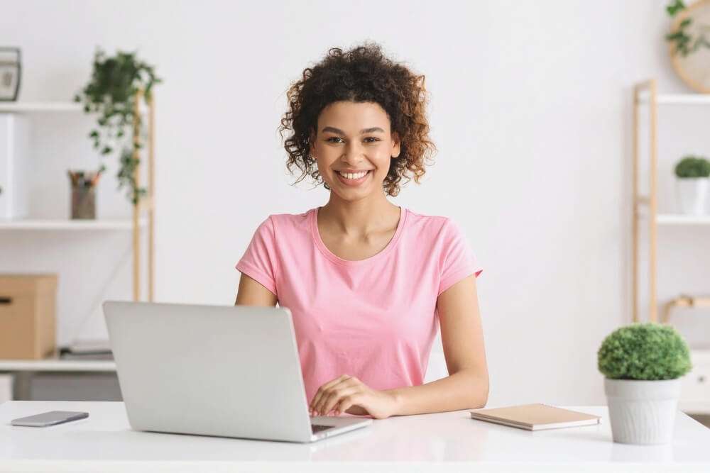 Headerbild Umsatzsteuervoranmeldung selber machen: Frau sitzt am Tisch mit einem Laptop.
