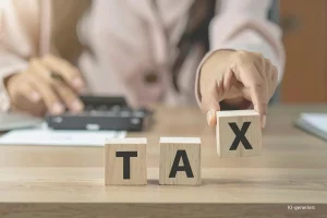 Titelbild: Steuern für Selbstständige. Frau stellt Würfel auf mit den Buchstaben TAX