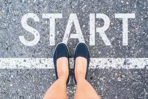 Headerbild Steuerglossar Fragebogen zur steuerlichen Erfassung. Frau steht auf Startlinie. Auf der Straße steht START.