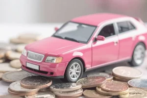 Headerbild Steuerglossar Kilometerpauschale. Pinkes Auto steht auf Geldmünzen.