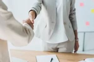 Headerbild Steuerglossar Lieferung und Sonstige Leistung. Zwei Businesspartner geben sich die Hand.