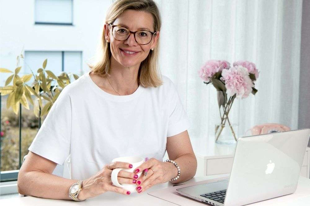 Barbara Hülsmann, Steuerberaterin, sitzt am Schreibtisch vor dem Laptop.