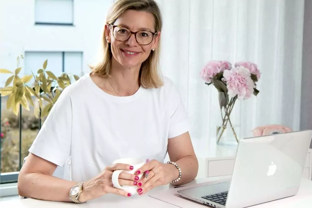 Barbara Hülsmann, Steuerberaterin, sitzt am Schreibtisch vor dem Laptop.