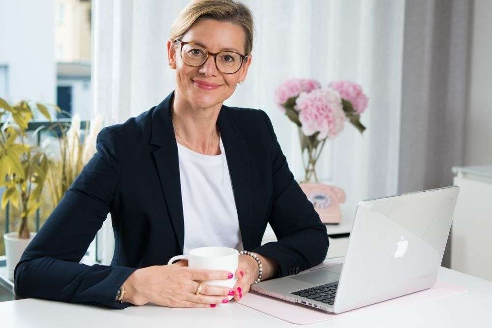 Barbara Hülsmann, Steuerberaterin, TaxLounge Consulting GmbH sitzt am Schreibtisch vor dem Laptop.